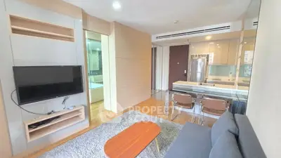 Modern living room with open kitchen, featuring sleek furniture and contemporary design.