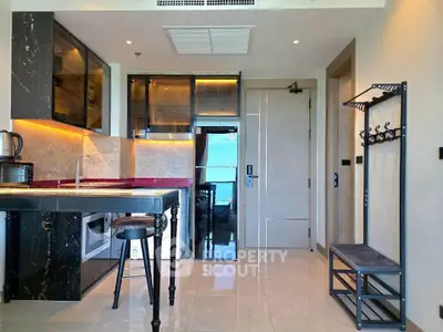Modern kitchen with sleek black cabinetry and stylish bar stool in a contemporary apartment.