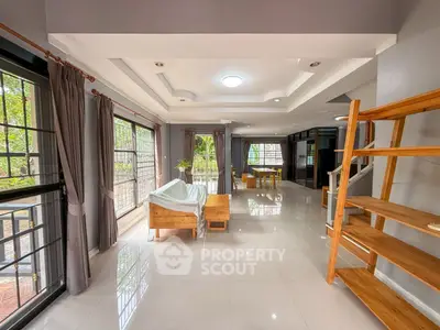 Spacious living room with large windows and modern decor, perfect for family gatherings.