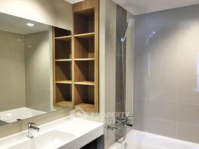 Modern bathroom with sleek fixtures and built-in wooden shelving