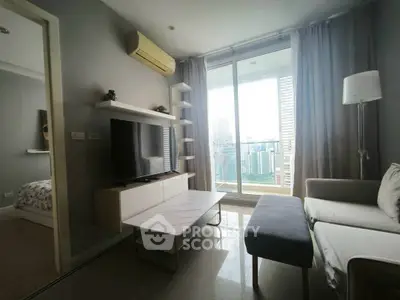 Modern living room with large window and balcony view, featuring stylish furniture and natural light.