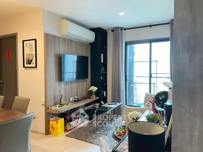 Modern living room with balcony, stylish decor, and ample natural light.