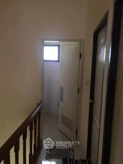 Cozy hallway leading to a bathroom with natural light