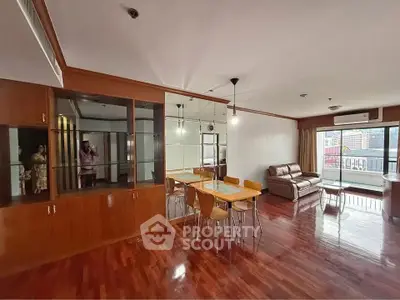 Spacious living room with wooden flooring and balcony view in modern apartment