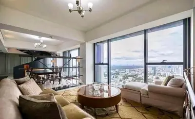 Luxurious living room with panoramic city view and elegant furnishings.