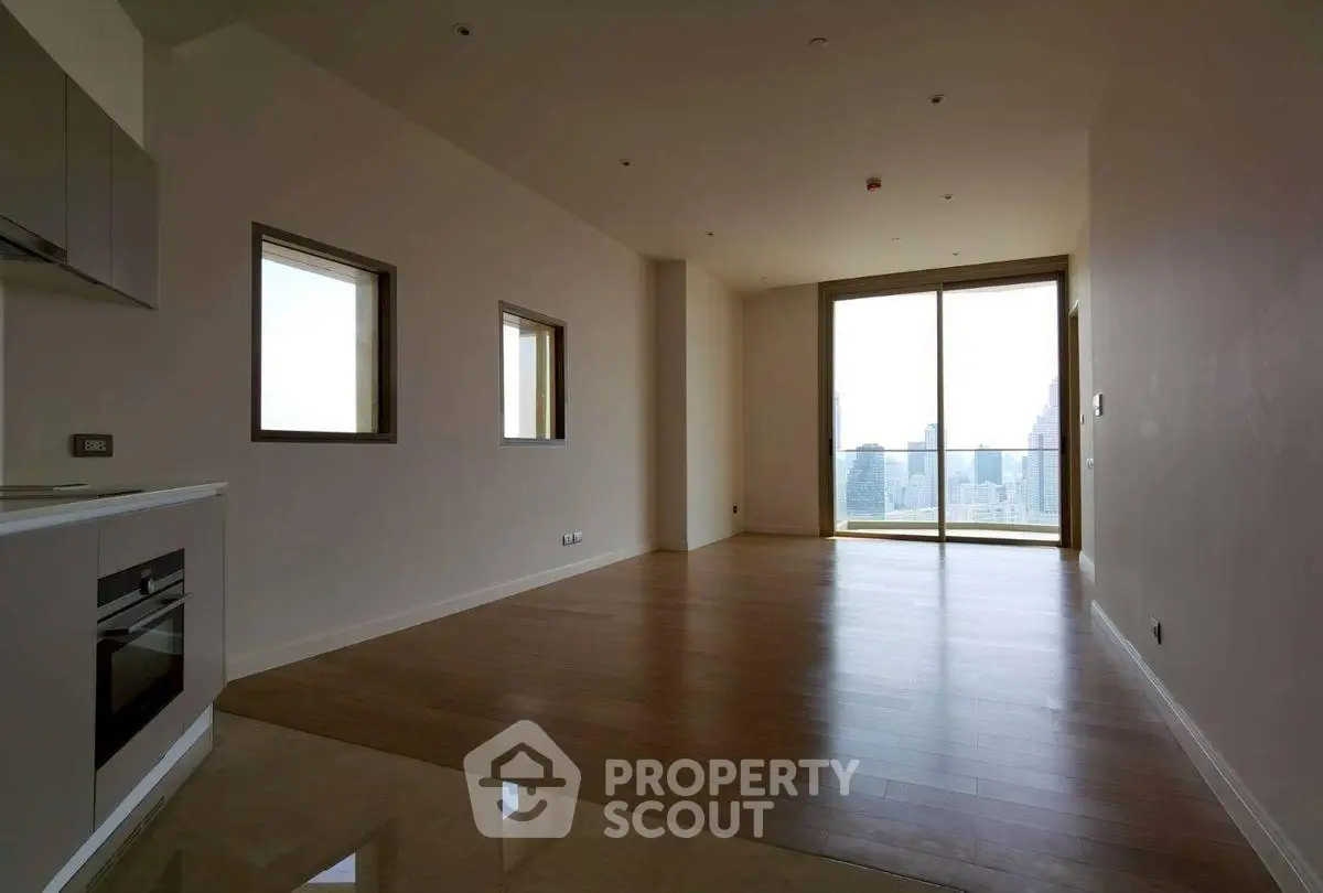 Spacious modern living room with city view and sleek kitchen area.