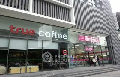 Modern commercial building exterior with coffee shop and convenience store.