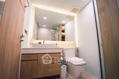 Modern bathroom with wooden cabinetry and sleek fixtures in a contemporary apartment.
