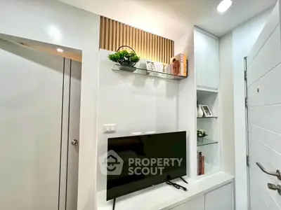 Modern living room with sleek TV setup and stylish decor in a contemporary apartment.