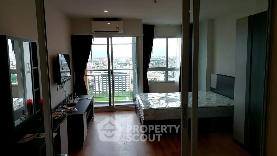 Modern bedroom with balcony and city view in high-rise apartment