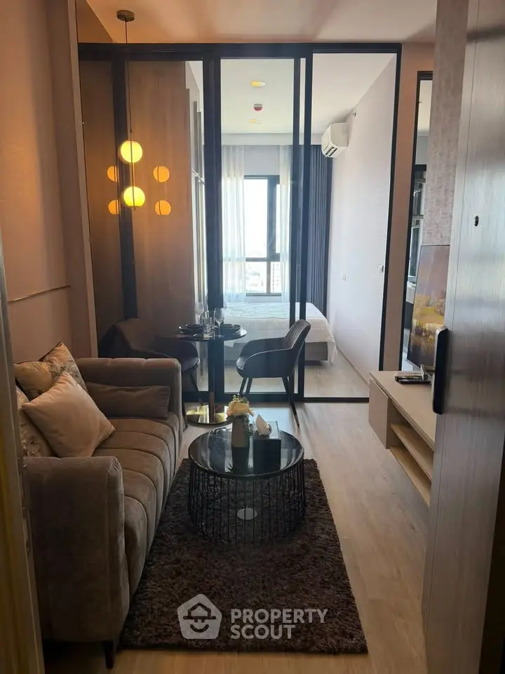 Modern living room with cozy seating and stylish decor in a compact apartment setting.