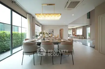 Luxurious open-plan dining and living area with elegant decor and large windows.