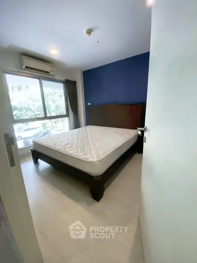 Spacious bedroom with large window and modern decor in prime location