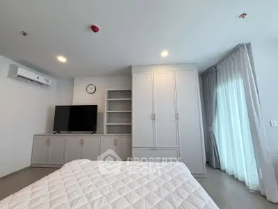 Modern bedroom with sleek built-in wardrobe and large window for natural light.