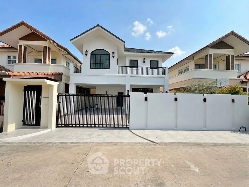 Stunning modern house with gated entrance and spacious driveway in a serene neighborhood.