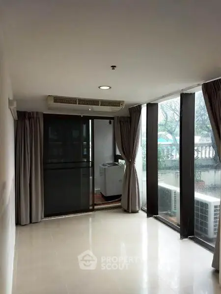 Spacious room with large windows and balcony access, perfect for natural light lovers.