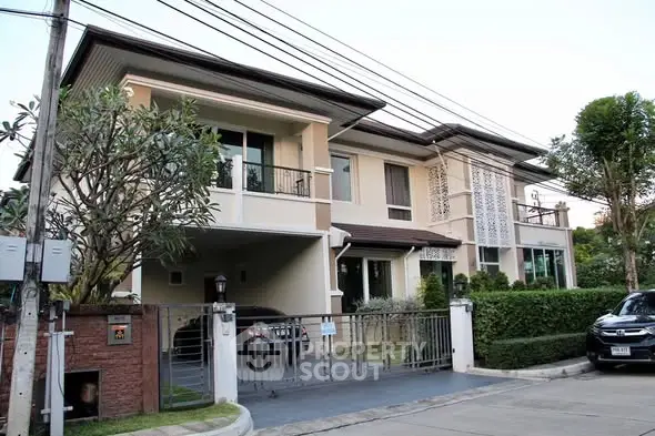 Elegant two-story house with modern design and lush greenery in a serene neighborhood.