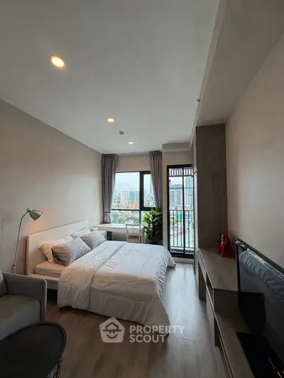 Modern bedroom with city view, cozy bed, and stylish decor in a high-rise apartment.