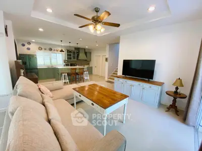 Spacious open-plan living room with modern kitchen and cozy seating area, perfect for family gatherings.