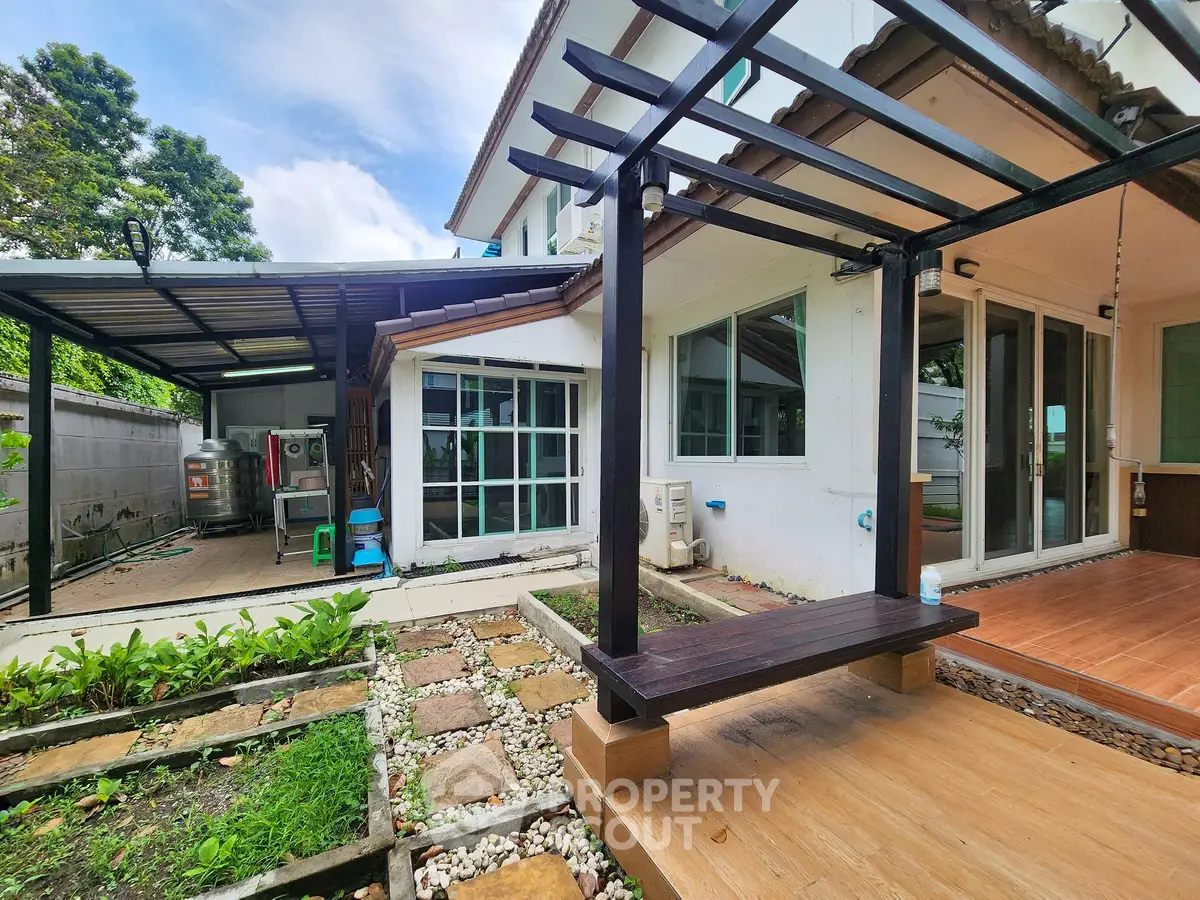 Charming house exterior with pergola and lush garden, perfect for outdoor relaxation.