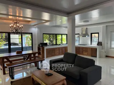 Spacious open-plan living room and kitchen with modern decor and natural light.