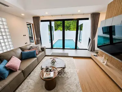 Luxurious living room with pool view, modern decor, and elegant furnishings.