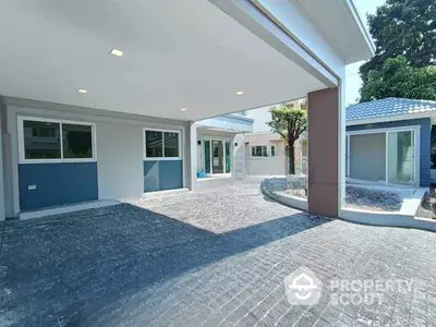 Spacious modern home with covered driveway and lush garden area, perfect for family living.