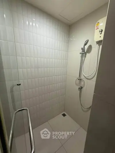 Modern bathroom with sleek shower and white tiled walls