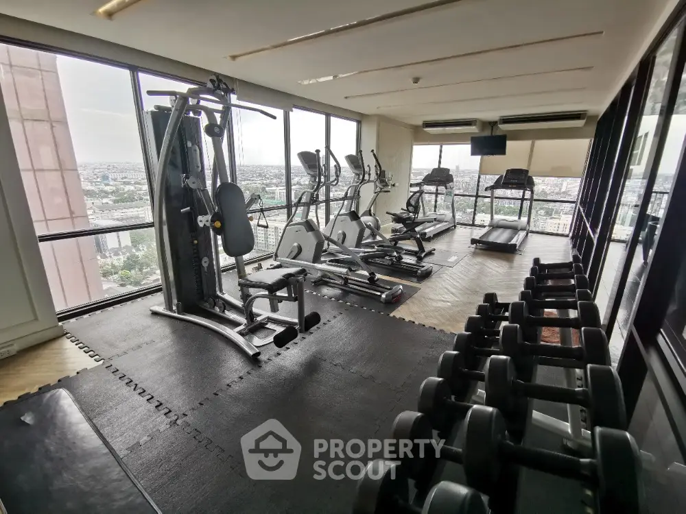 Modern high-rise gym with panoramic city views and state-of-the-art fitness equipment.