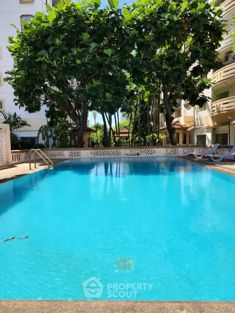 Luxurious residential pool surrounded by lush greenery and elegant architecture, perfect for relaxation and leisure.