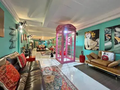 Stylish living room with unique decor and vibrant colors, featuring a pink telephone booth and modern art.