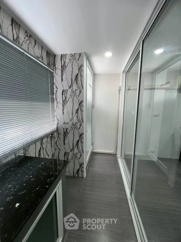 Modern bathroom with marble accents and sleek glass shower doors