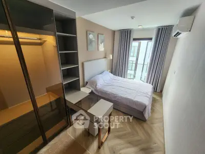 Modern bedroom with elegant decor and large window offering natural light and city view.