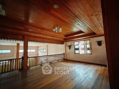 Spacious wooden interior with large windows and decorative wall mounts, perfect for a cozy living area.
