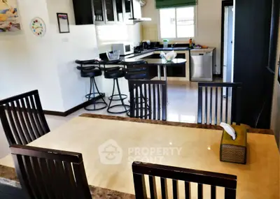 Spacious kitchen and dining area with modern appliances and stylish bar stools.