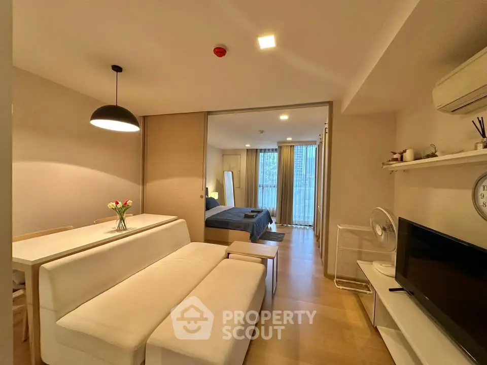 Modern open-plan living room with cozy seating and stylish decor in a contemporary apartment.