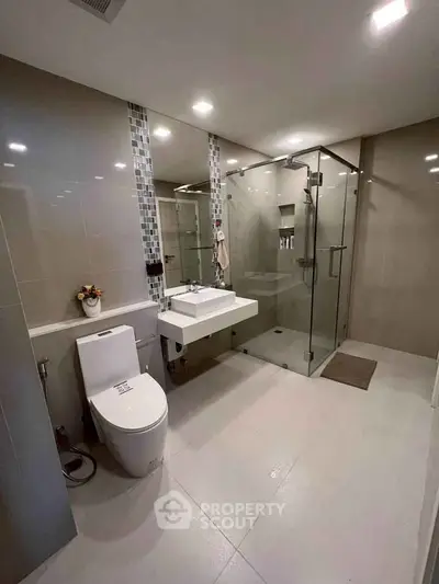 Modern bathroom with glass shower and sleek fixtures in luxury home.