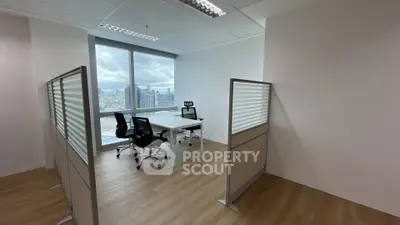 Modern office space with city view, featuring sleek furniture and ample natural light.