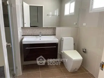 Modern bathroom with sleek vanity and large mirror in a stylish home.