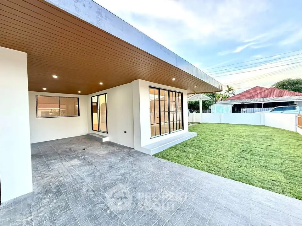 Modern single-story home with spacious patio and lush green lawn