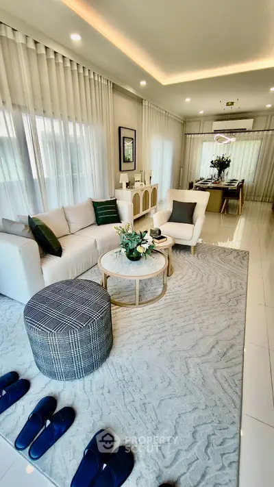 Elegant living room with modern decor and open layout, featuring plush seating and stylish accents.