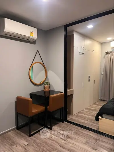 Modern bedroom with stylish decor and compact workspace, featuring sleek furniture and warm lighting.