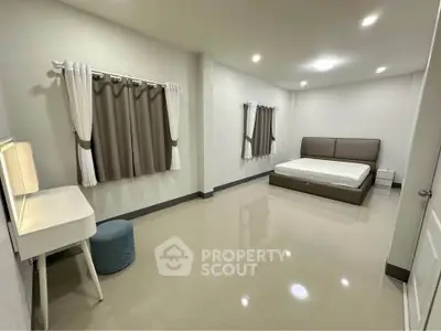 Spacious modern bedroom with minimalist design and elegant furnishings.