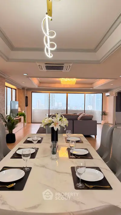 Luxurious open-plan living and dining area with city views, elegant lighting, and modern furnishings.