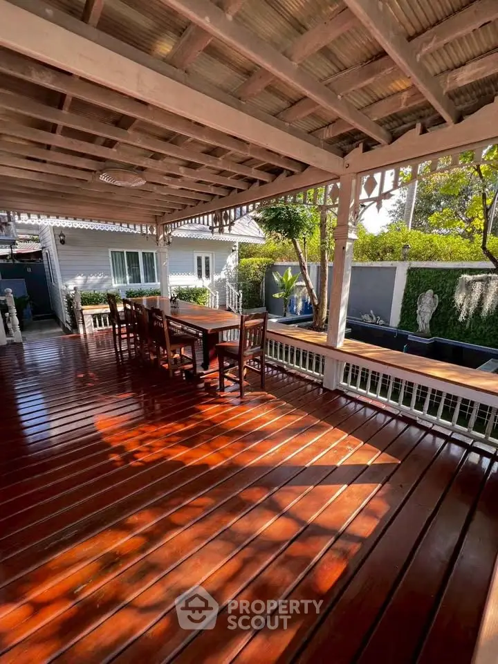 Spacious wooden deck with outdoor seating and lush garden view, perfect for relaxation and entertaining.