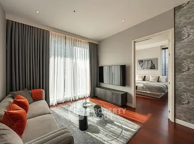 Modern living room with stylish decor and view into cozy bedroom