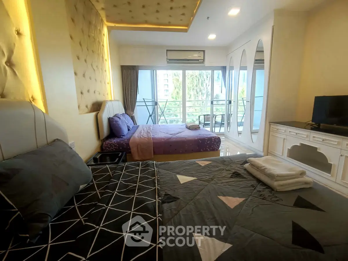 Spacious bedroom with two beds and balcony view in modern apartment