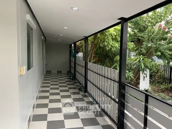 Spacious balcony with checkered flooring and garden view