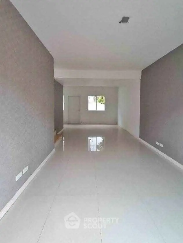 Spacious empty room with glossy tiled flooring and neutral walls, ideal for customization.