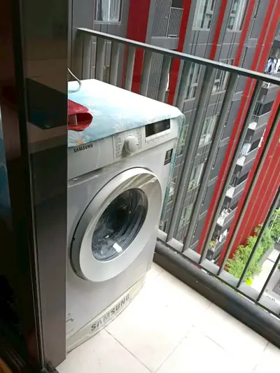 Modern apartment balcony with washing machine and urban view